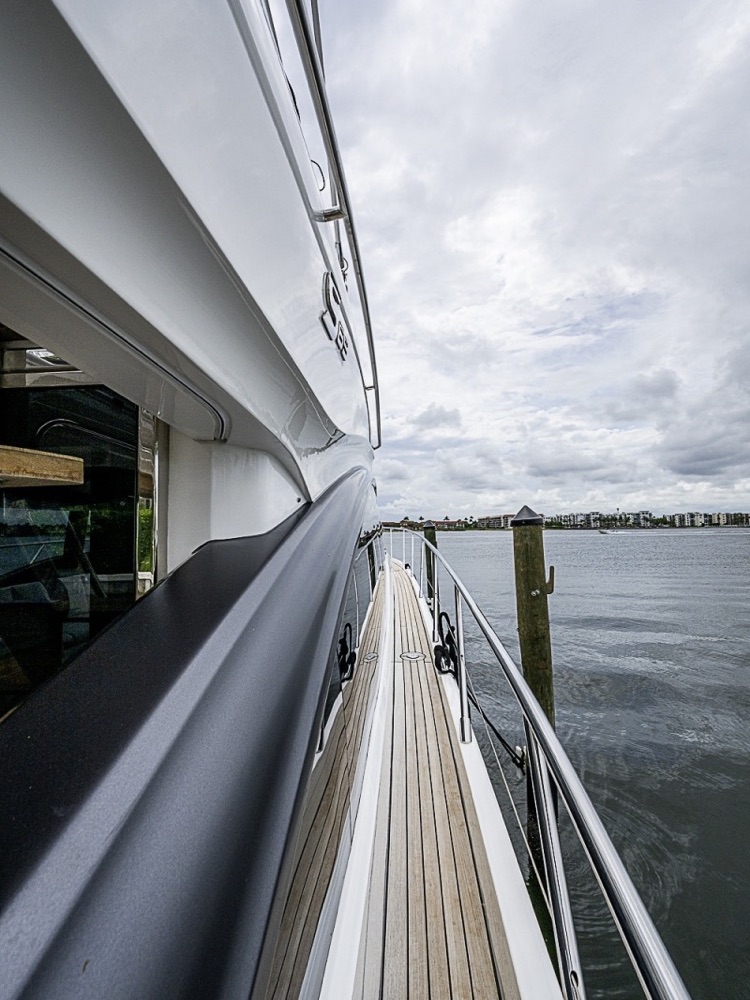 The side deck of a 65-foot yacht alongside the dock