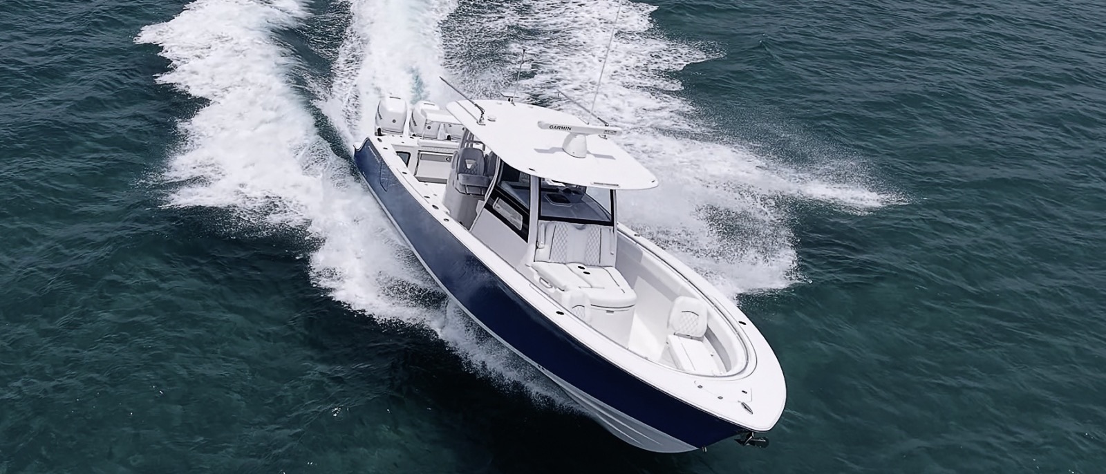 A 35-foot center console running offshore with a long wake