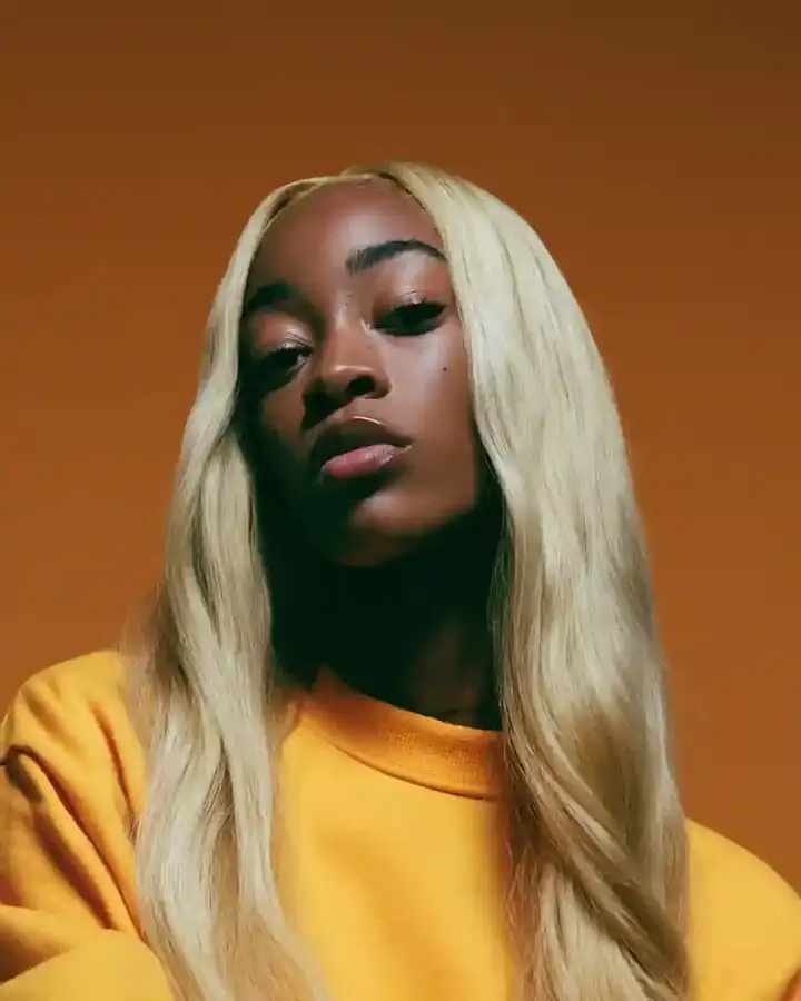 Long blonde straight hair against an amber backdrop