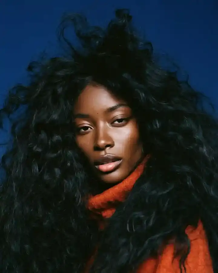 Long dark waves with an orange scarf, blue backdrop