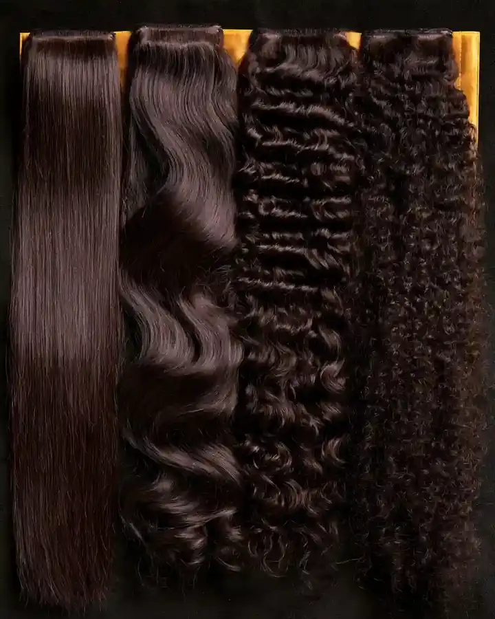 Hair lengths laid side by side on a dark surface, straight through to coiled