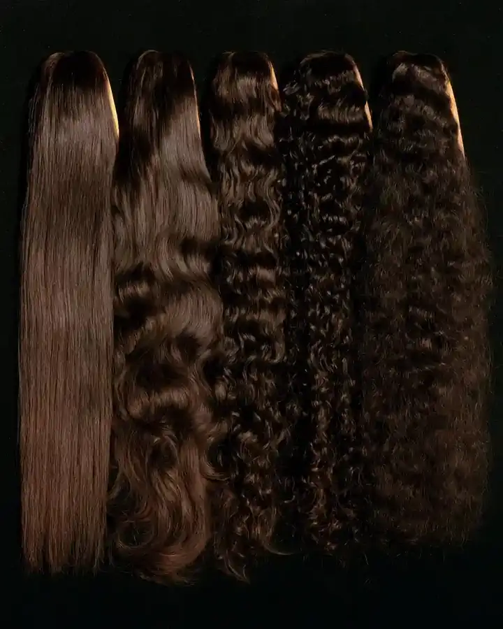 Hair lengths laid side by side on a dark surface, straight through to coiled