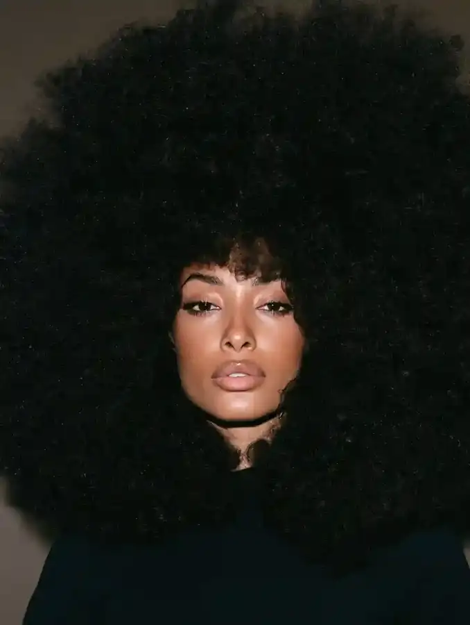 4C coil afro against a soft black backdrop
