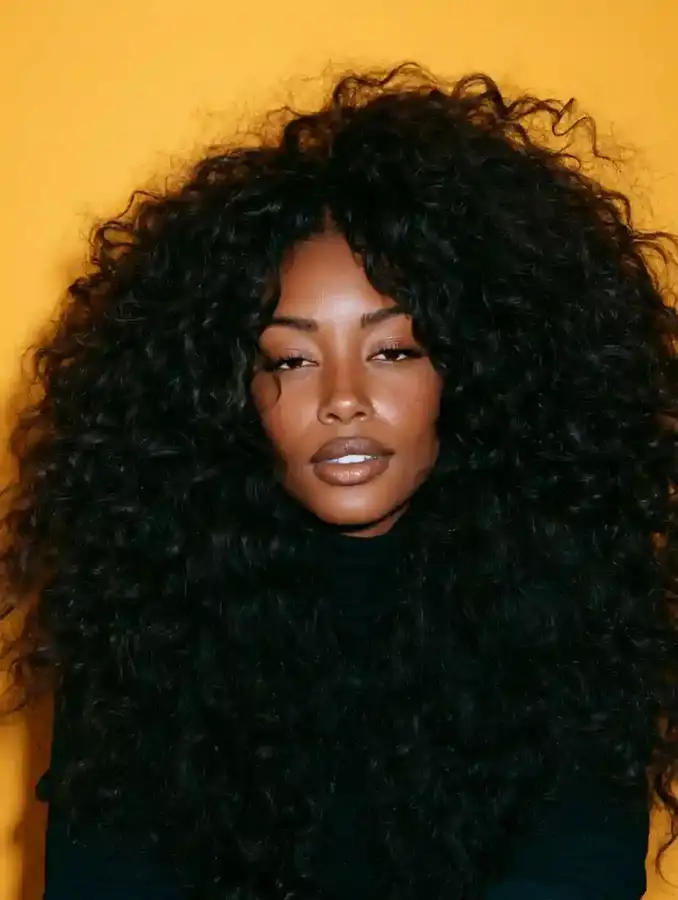 Curly hair portrait against a saffron backdrop