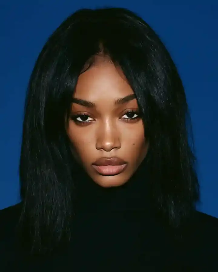 Bone-straight jet black hair with a centre part, blue backdrop