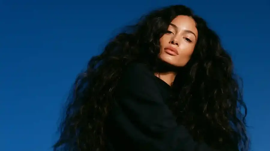 Curly hair against a deep blue backdrop, wide frame