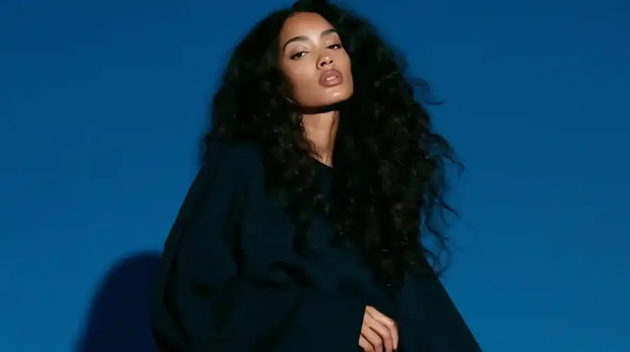 Curly hair against a deep blue backdrop, wide frame
