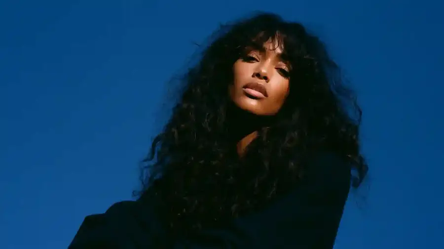 Curly hair against a deep blue backdrop, wide frame
