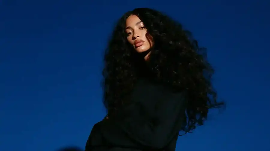 Curly hair against a deep blue backdrop, wide frame