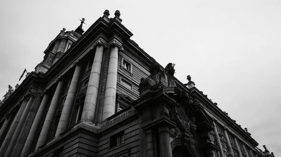 Monumental stone facade of a Spanish supreme court, low angle under an overcast sky
